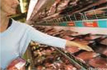 consumer picking up pork product of supermarket shelf